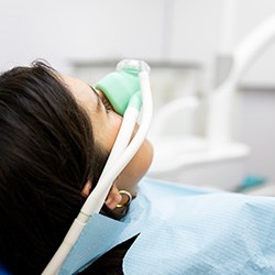 Closeup of woman breathing in nitrous oxide at dentist’s office