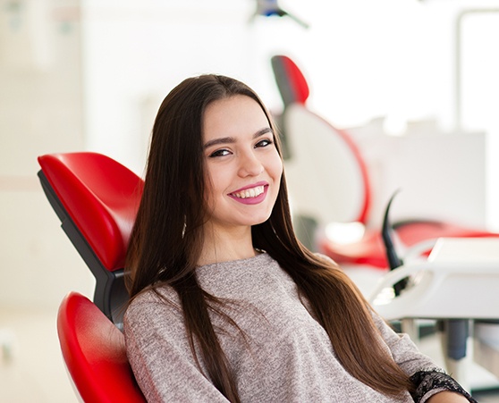 woman smiling while sitting in chair 