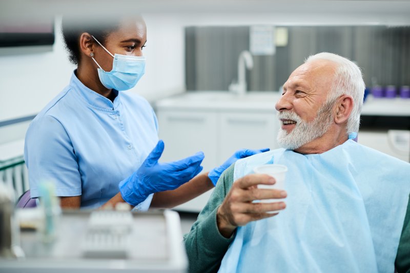 dental hygienist helping patient