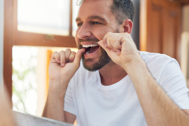 Patient flossing their dental implants